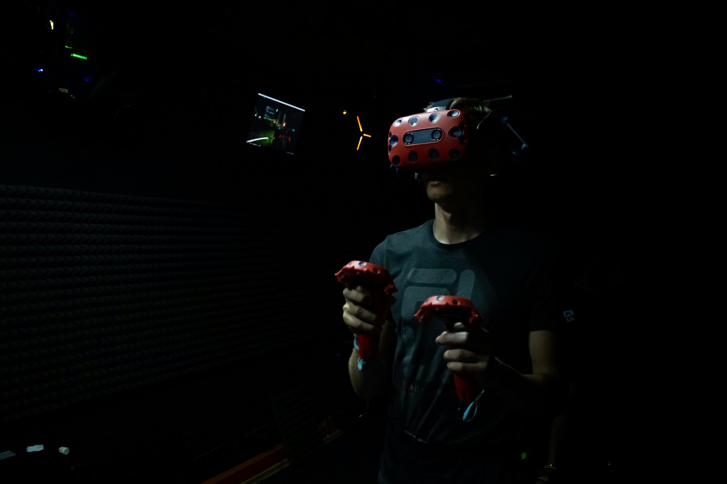 Persona con visore VR rosso e due controller in mano.