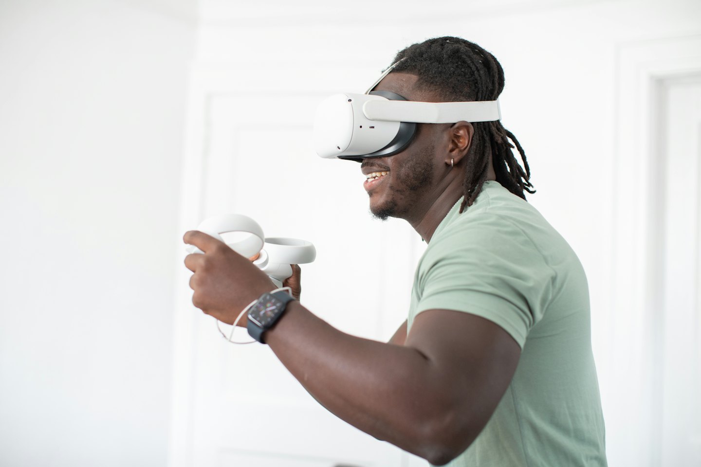 Un uomo con visore VR sorride tenendo i controller.