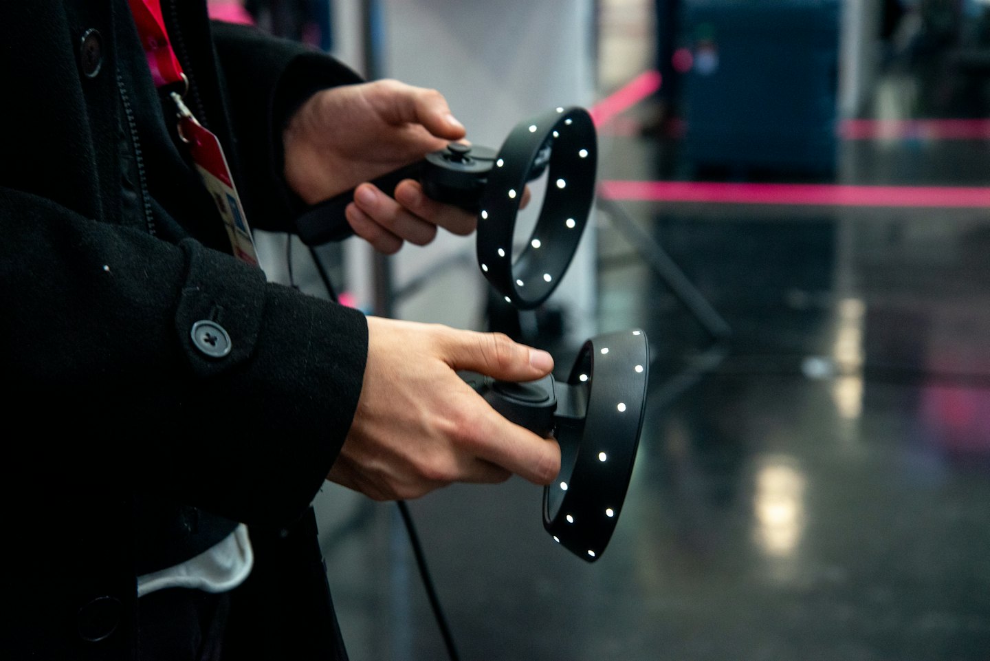 Mani che usano due controller VR neri con punti di tracciamento bianchi.